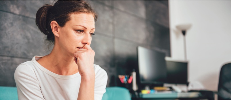 Woman sitting on couch thinking about something 